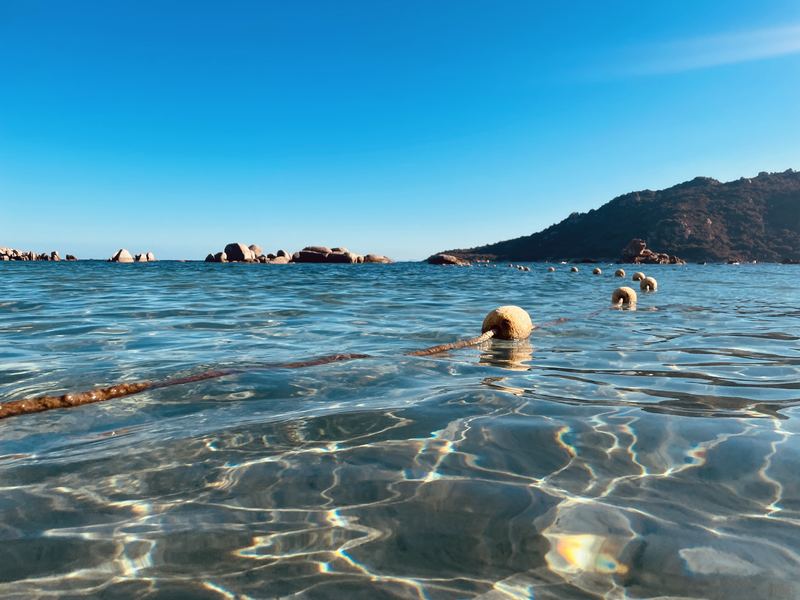 Eau cristalline et bouées de la zone de baignade de Santa Giulia